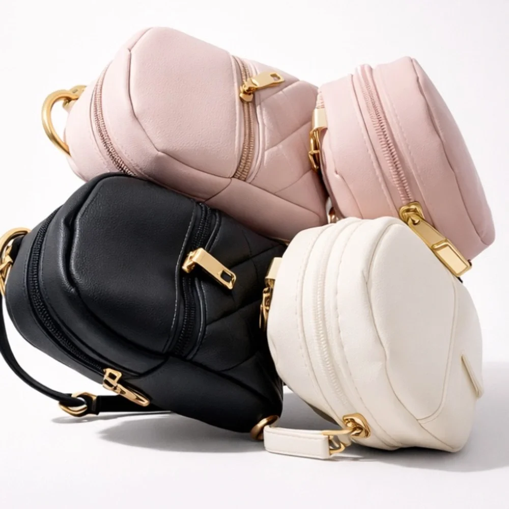 Mini backpack keychain charms, blue, pink, black, cream colors.